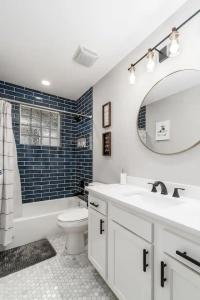 a bathroom with a sink and a toilet and a mirror at 2 homes side by side downtown with fenced yard and hot tub in Columbus