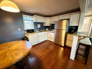 a kitchen with white cabinets and a wooden table at Cottage 6- Lees Ford Marina in Nancy
