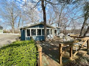 a blue house with a picnic table and chairs at Cottage 1- Lees Ford Marina in Nancy