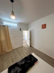 an empty living room with a bed and a lamp at Chambre spacieuse avec balcon - salle de bain extérieure privée & breakfast in Saint-Louis