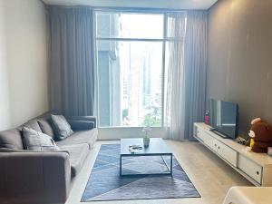 2bedroom soho suites klcc في كوالالمبور: غرفة معيشة مع أريكة وتلفزيون