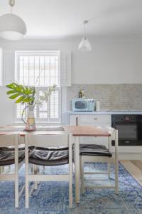 a kitchen with a table and some chairs and a table at Bright 3 Bedroom House Near King's Cross StPancras in London