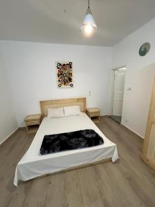 ein Schlafzimmer mit einem großen weißen Bett in einem Zimmer in der Unterkunft Chambre spacieuse avec balcon - salle de bain extérieure privée & breakfast in St. Louis