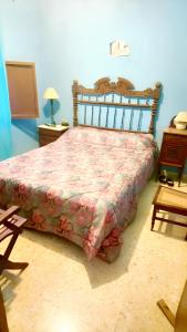 um quarto com uma cama com colcha floral em 3 bedrooms house with enclosed garden at Simat de la Valldigna em Bárig
