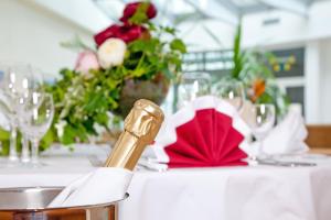 einen Tisch mit einer Flasche Wein und Blumen darauf in der Unterkunft Parkhotel Rügen in Bergen auf Rügen