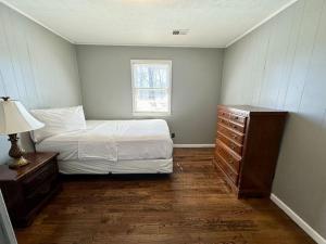 a bedroom with a bed and a dresser and a window at Cottage 17- Lees Ford Marina in Nancy