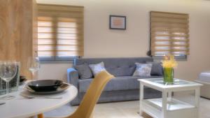 a living room with a couch and a table at Loutsiana Apartments Corfu in Alykes Potamou