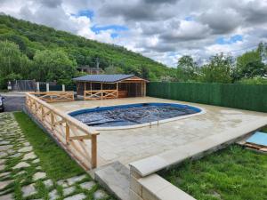 uma piscina com um gazebo num quintal em Casa Senik Monteoru em Merei