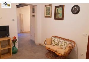 ein Wohnzimmer mit einem Stuhl und einer Uhr an der Wand in der Unterkunft Corte Veneta in Castelnuovo del Garda