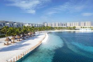 a beach with chairs and umbrellas and the ocean at OceanPark Amazing Cozy Modern great view 3Beds in Gia Lâm Pho