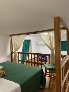 Un dormitorio con una cama verde y una silla en CASA VACANZE CANAL GRECO - B&B en Castrovillari