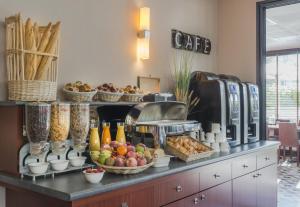 a buffet with bread and fruit on a table at Plessis Parc Hôtel in Le Plessis-Robinson
