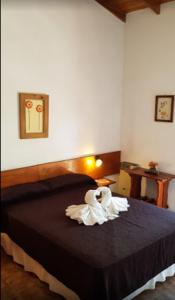 un dormitorio con una cama con una decoración de cisne en La Posada del Rey en Mina Clavero