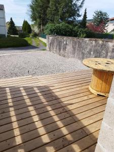 une terrasse en bois avec une table en bois. dans l'établissement Gîte l'harmonie I, à Fraize