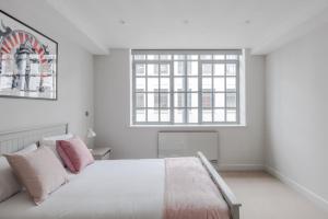 ein weißes Schlafzimmer mit einem Bett und einem Fenster in der Unterkunft Circus of Colour - Farringdon - by Frankie Says in London