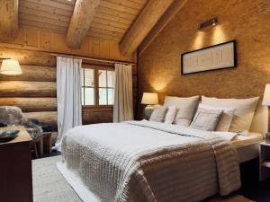 a bedroom with a large bed and a wooden wall at 0 Simple - The Heiti Lodge in Gsteig