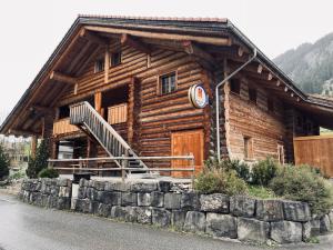 a log cabin with a staircase in front of it at 0 Simple - The Heiti Lodge in Gsteig