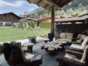 a patio with couches and tables and a playground at 0 Simple - The Heiti Lodge in Gsteig