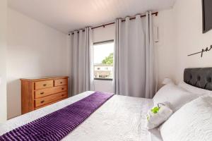 a bedroom with a large bed and a window at Casa Do Trevo - Cantinho de PAZ, HARMONIA e LAZER ! in Paraty