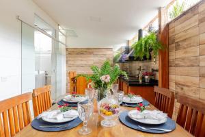 a dining room table with plates and glasses on it at Casa Do Trevo - Cantinho de PAZ, HARMONIA e LAZER ! in Paraty