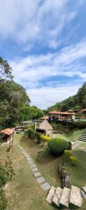 a garden with a building in the background and a building at Pousada do Coura in Pouso Alto