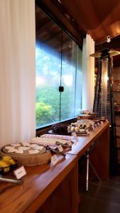 a table with food on it with a large window at Pousada do Coura in Pouso Alto