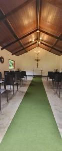 a church with a green carpet in a room with a cross at Pousada do Coura in Pouso Alto