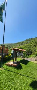 a sign in the grass next to a flag at Pousada do Coura in Pouso Alto