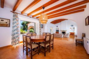 a dining room with a wooden table and chairs at Casa Aladern On The Beach Mhm in Font de Sa Cala
