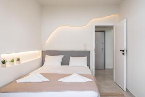 a white bedroom with a large bed with white pillows at S12 Apartments in Heraklio Town