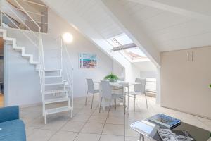 a living room with a staircase and a table and chairs at Politecnico & Crocetta Elegant Flat in Turin