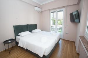 a bedroom with a large white bed and a window at Elegant Apartment Downtown Athens II in Athens