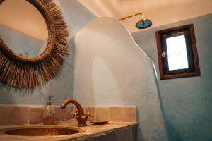 ein Bad mit einem Waschbecken und einem Spiegel in der Unterkunft Dar Haroun in Rissani