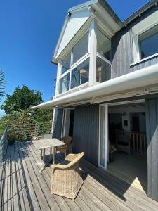 a wooden deck with a table and chairs on a house at Cottage Pêcheur + Annexe 12pers vue Mont St-Michel in Champeaux +23 photos