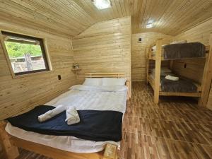 a bedroom with a bed in a wooden cabin at Casute la "Doi pasi de Castel" in Hunedoara