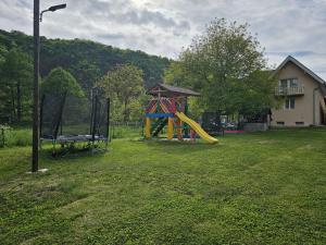 a playground with a slide in a yard at Casute la "Doi pasi de Castel" in Hunedoara