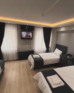 a hotel room with two beds and a flat screen tv at Sezgin Deluxe Hotel in Istanbul