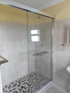 a shower with a glass door in a bathroom at Hlophe's Place in Hibberdene +130 photos