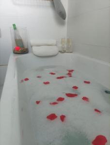 Baño blanco con flores rojas en el suelo en La posada del Kintsugi, en Pilas