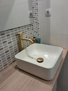 a white sink with a gold drain in a bathroom at Apartamento Rúa Centro Balcony Calatayud in Calatayud +11 photos
