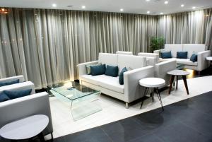 a living room with couches and tables and curtains at Beramar Hotel in Praia