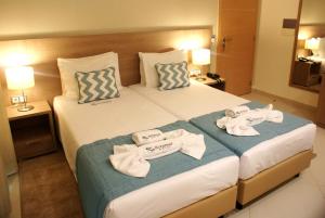 um quarto de hotel com duas camas com toalhas em Beramar Hotel em Praia