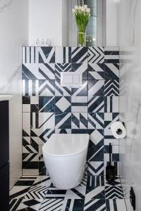 baño con una pared de azulejos en blanco y negro en Budget Apartment Gliwice 1min from Main Square, en Gliwice