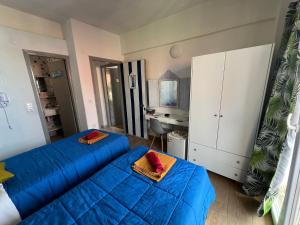 Habitación con 2 camas azules y escritorio. en Avra Boutique en Benitses