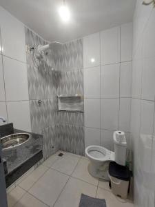 a bathroom with a toilet and a sink at Acomodações no Jardim Tropical em Rondonópolis in Rondonópolis