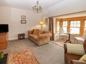 a living room with a couch and a television at Plum Tree Cottage in Castleton