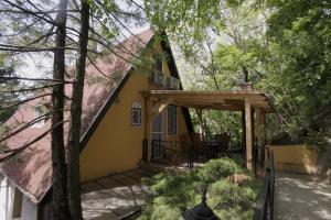 a yellow house with a porch and a deck at Villa Anita - 100 metrov od pláže Bercsényi in Balatonakarattya
