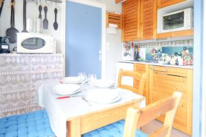 a kitchen with a table with plates on it at Studio au calme quartier Port Olona Les Sables 4 personnes in Les Sables-dʼOlonne
