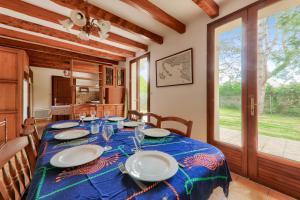 a dining room with a table with plates on it at Maison pour 8 avec jardin entre Plages et Golfe in Sarzeau