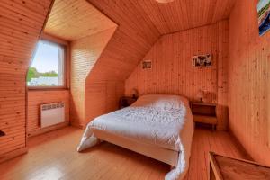 a bedroom with a bed in a wooden room at Maison pour 8 avec jardin entre Plages et Golfe in Sarzeau